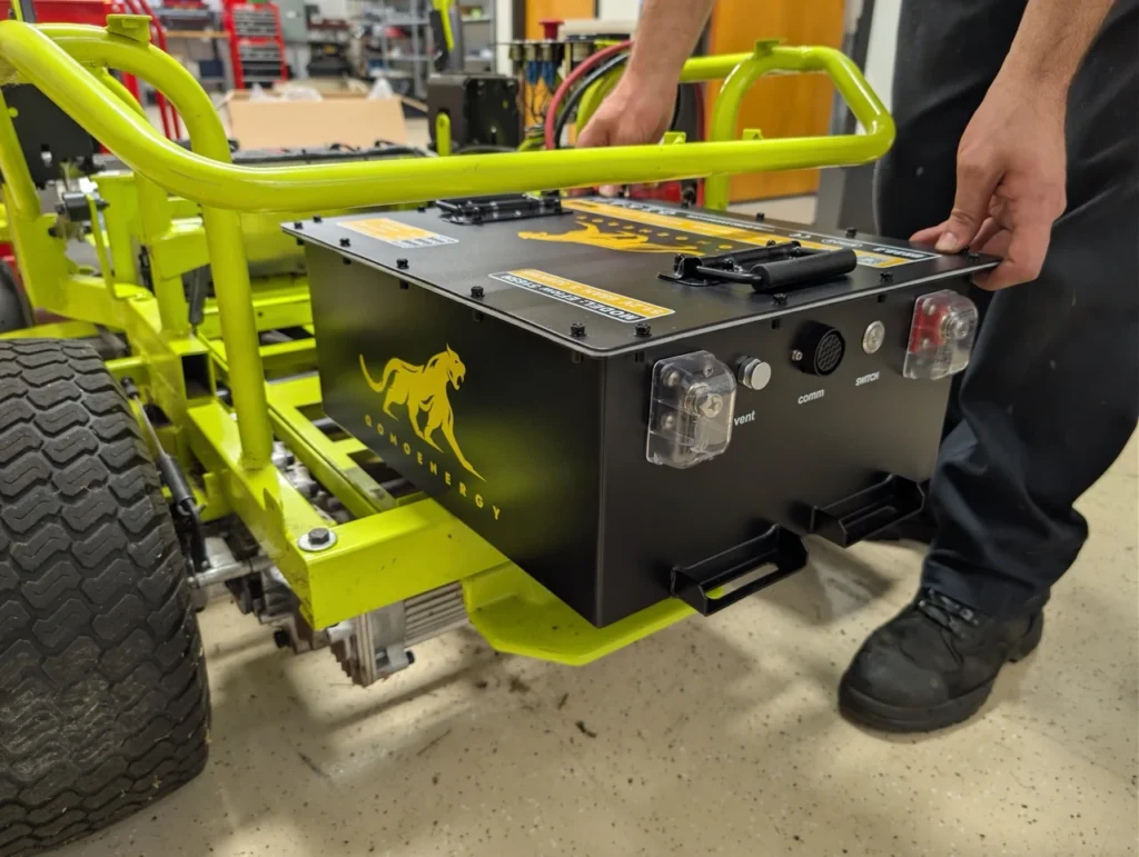 Sliding the new Qomo battery into the battery compartment as part of the Ryobi ZT480 Battery Upgrade.