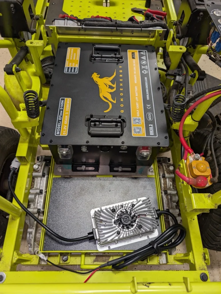 Top view of the new Qomo Lithium battery being installed into the Ryobi riding mower.